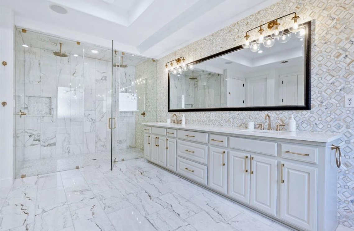 Spa-like primary bathroom at 1075 Hawkwood Way Allen TX — marble floors, glass shower, gold fixtures
